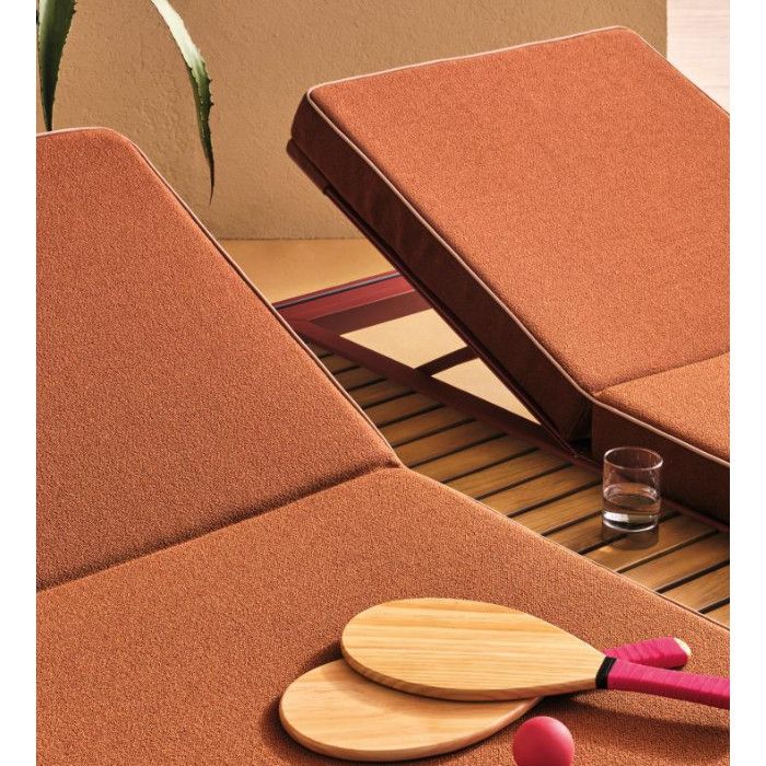 Close-up of Fibra XL double sun lounger showing terracotta textured fabric, teak slats, and wooden beach paddles.