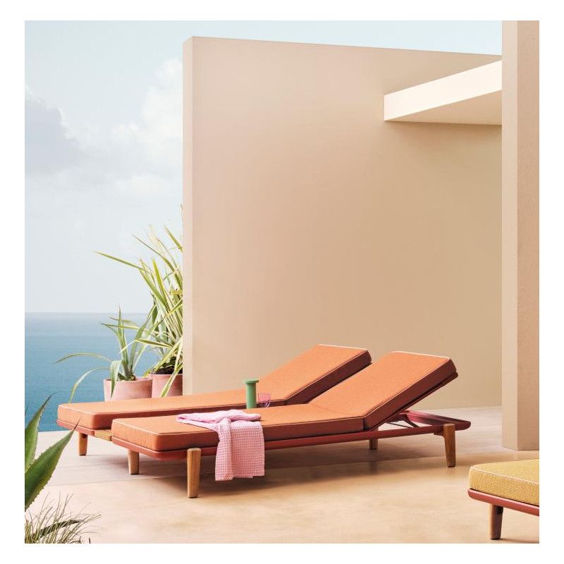 Wide view of Fibra XL double sun lounger with apricot cushions, metal frame, and pink towel on a coastal patio.