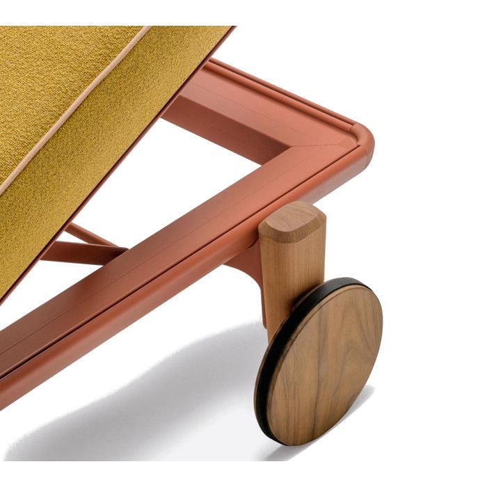 Close-up detail of the Fibra W Sun Lounger showing a textured yellow cushion, terracotta metal frame, and wooden wheel.