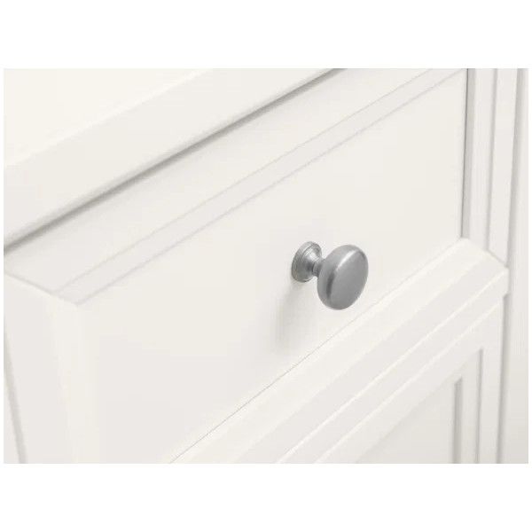 Close-up view of a white Maine bedside table drawer with a round metallic handle and clean panelled design.