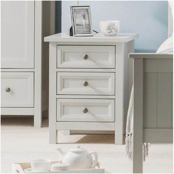 Maine bedside table in white featuring three drawers, set in a bedroom with a tea tray in the foreground.