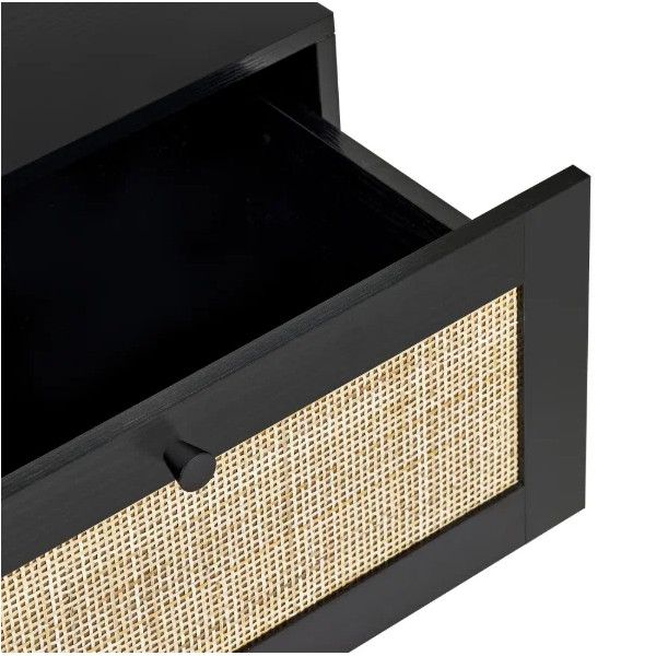 An open drawer on a black Padstow bedside unit, showcasing the natural cane weave front and matching minimalist handle.