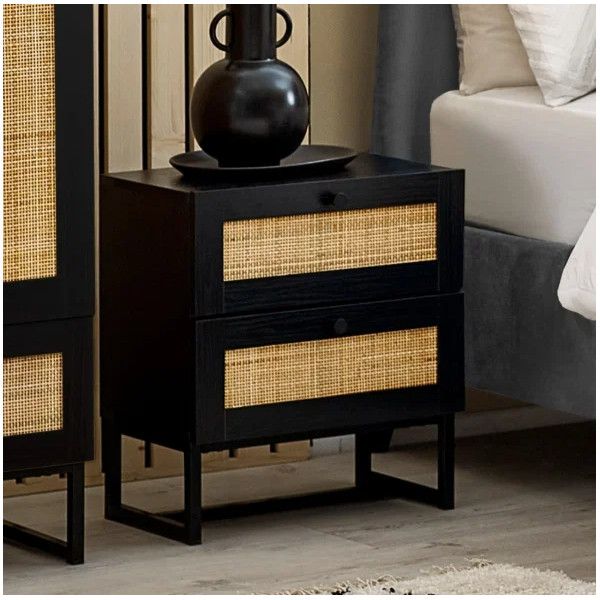 Padstow bedside table in black wood featuring dual drawers with natural rattan inlay and a sturdy sled-style frame.