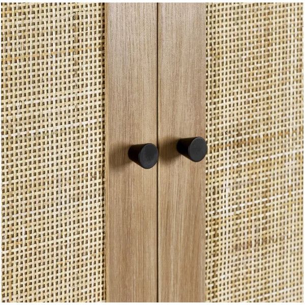 Detail shot of the Padstow wardrobe featuring vertical oak trim and contrasting matte black knobs against rattan weave.