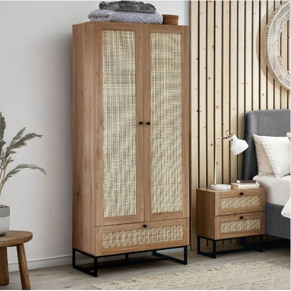 Angle view of an oak Padstow wardrobe showing rattan-panelled doors and base drawer, set beside a matching nightstand.