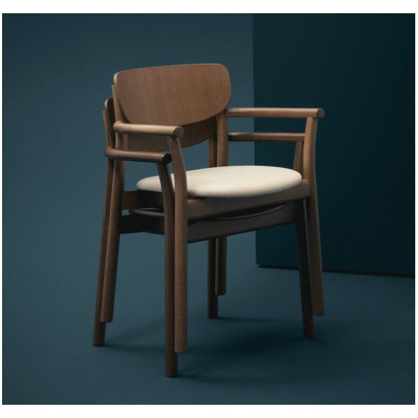 Stack of Zelda armchairs in dark wood with cream seat pads, presented from a side angle against a deep teal backdrop.