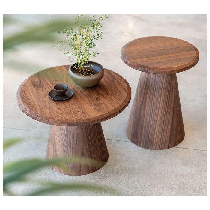 Artur Coffee Table set: two round walnut tables with tapered bases, one styled with a cup and potted plant.