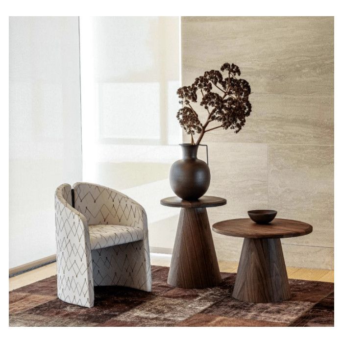 Artur Coffee Table: round dark wood top on tapered base, styled with a small bowl next to an armchair and vase.