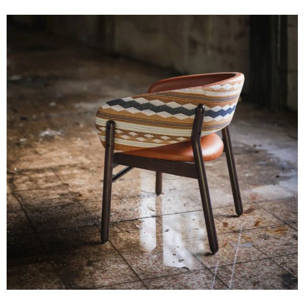 Rear view of the Camille S Lounge Chair showing geometric patterned fabric back, orange leather seat, and dark wood legs